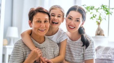 Three generations of women smiling for a photo